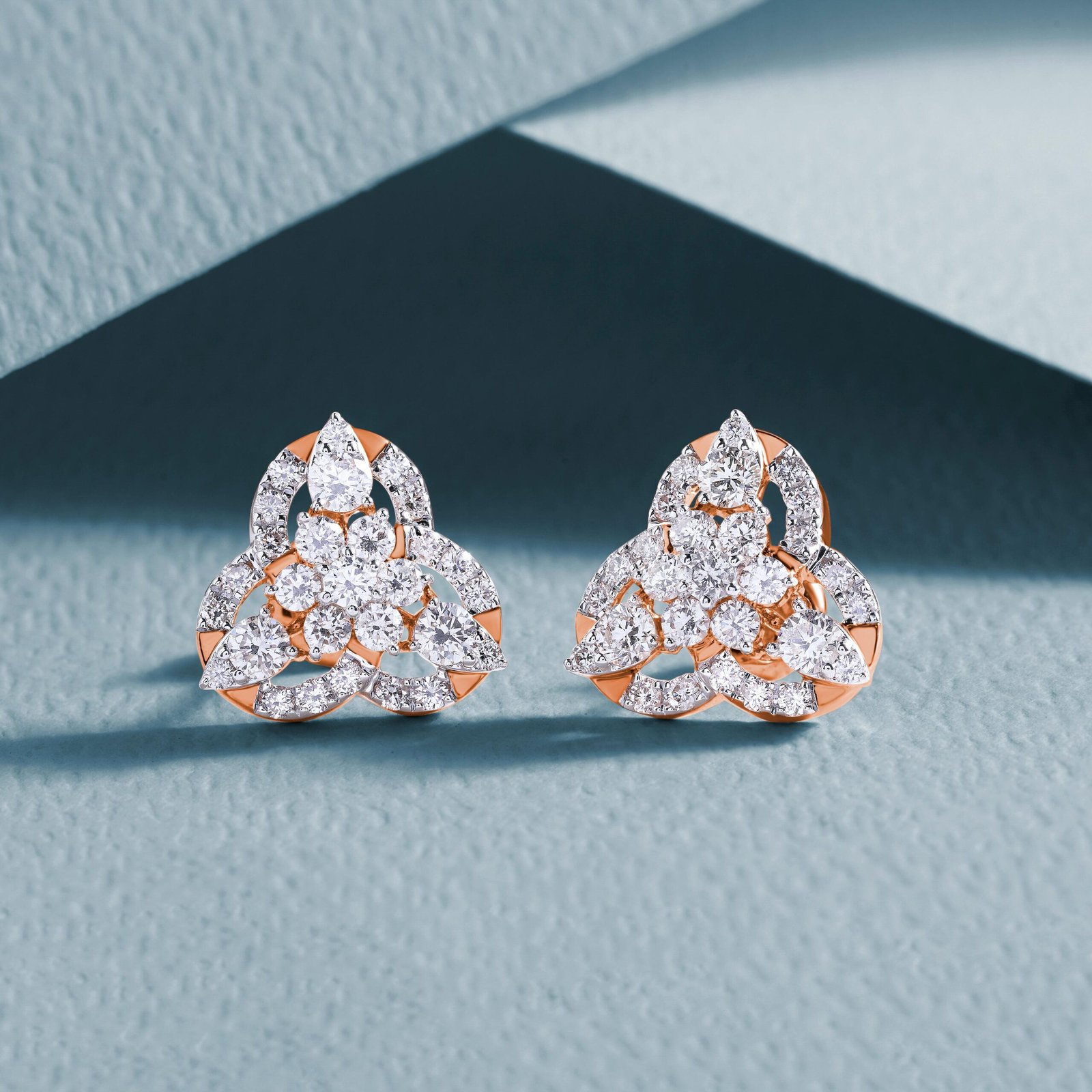 pexels-photo-10976654-10976654 Luxurious diamond earrings with an intricate design on a textured background.